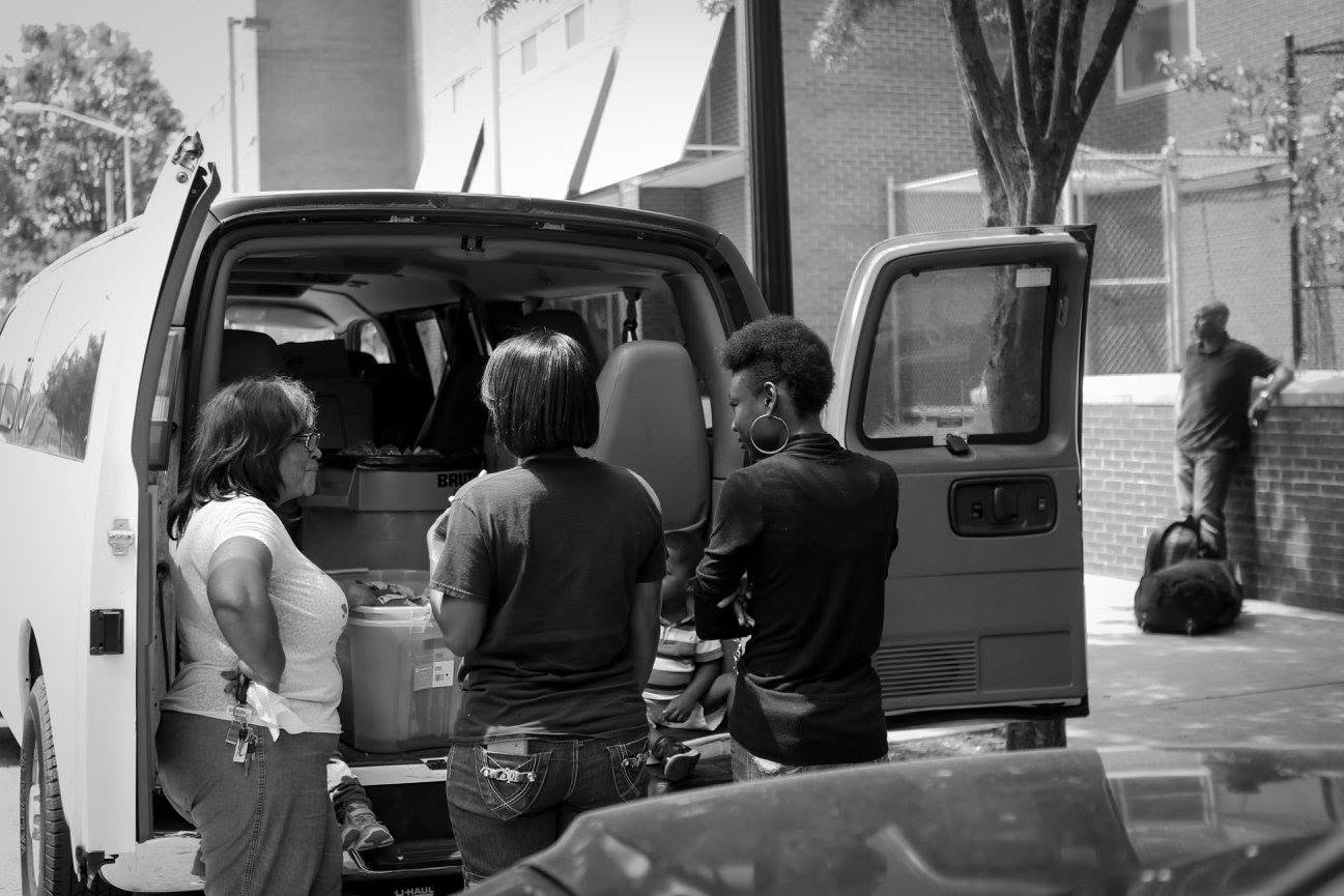 Communities In Action team members loading supplies from the outreach van